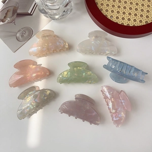 Close-up of 8 colorful acrylic hair claws with pearl luster and shell-like finish
