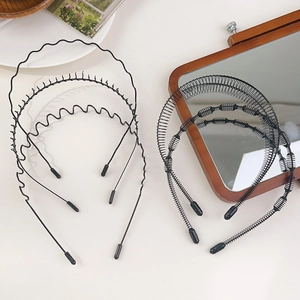 Détail d'un ensemble de 6 serre-têtes en métal noir avec divers motifs ondulés