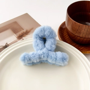 Détail de la pince à cheveux en peluche bleu ciel montrant la texture douce de la fausse fourrure