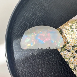 Detailed macro view of pearlescent acetate hair claw clip with colorful iridescent texture