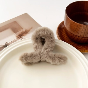 Détail de la texture pelucheuse kaki et du ressort métallique interne de la pince