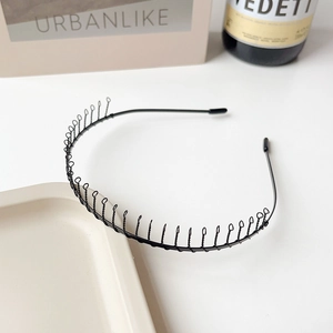 Détail d'un serre-tête métallique ondulé noir avec dents de peigne et embouts de protection