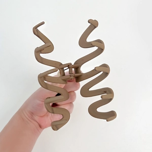 Matte dark brown large wave hair claw clip with irregular curved design for women