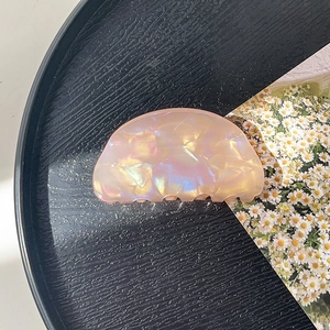 Detailed macro view of the pink pearlescent acrylic hair claw clip with shell luster finish