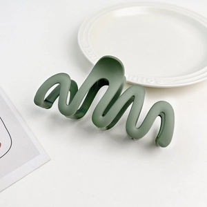 Detail view of large Morandi green matte hair claw clip with wavy curve design