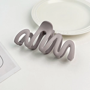 Detailed view of irregular wavy matte hair claw clip in elegant grey-purple finish