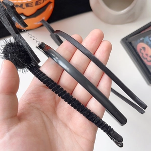 Close-up of black Halloween headbands including satin and velvet devil horn designs