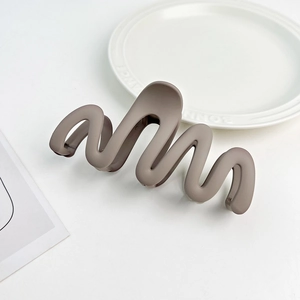 Detail view of the matte Morandi wave hair claw clip with a sleek S-shaped curve