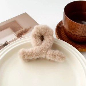 Détail de la texture en fausse fourrure pelucheuse et du ressort métallique de la pince à cheveux
