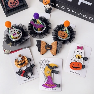 Macro detail of Halloween hair clips featuring glitter pumpkins, ghosts, and velvet bows