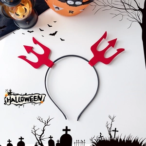 Detail view of a Halloween devil trident headband with red glitter elements on a black band