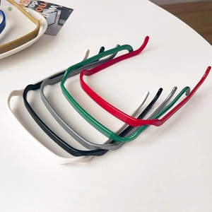 Détail d'un ensemble de serre-têtes carrés colorés posés sur une table au style épuré