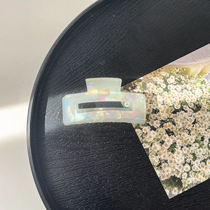 Detailed view of iridescent rectangular hair claw clip with pearlescent opal finish