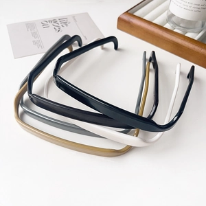 Détail de serre-têtes carrés style lunettes en résine noire, grise, blanche et ambre