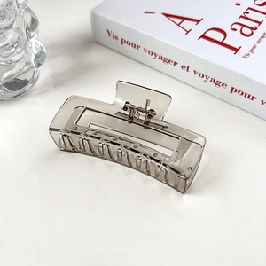 Détail d'une grande pince à cheveux rectangulaire creuse en finition marron thé ambré
