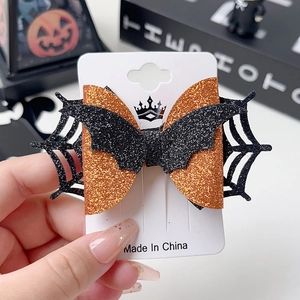 Detail of Halloween hair clips with orange glitter spider webs and black bats