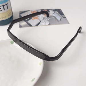 Serre-tête carré noir minimaliste posé sur une assiette décorative blanche en scène de vie
