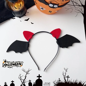 Detail view of Halloween headband with red devil horns and black felt bat wings for party