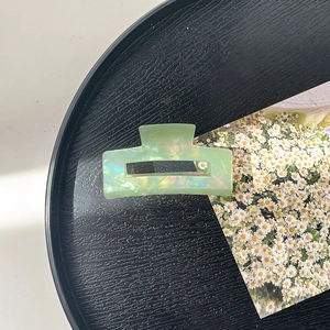 Detail of light green iridescent acrylic hair claw clip with rectangular cutout