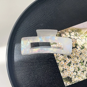 Close-up of translucent pearlescent acetate hair claw clip with colorful iridescent finish