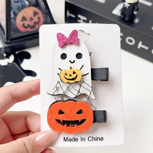 Close-up of Halloween hair clips with white ghost and orange pumpkin on card