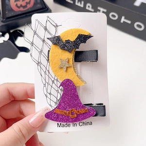 Detail of Halloween hair clips with glittery witch hat and yellow felt moon on display card