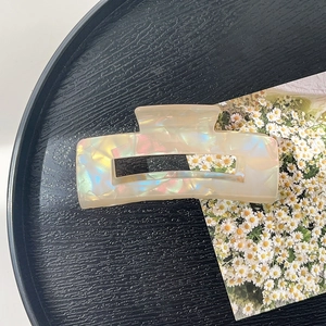 Close-up of minimalist rectangular hair claw clip with pearlescent acetate finish on tray