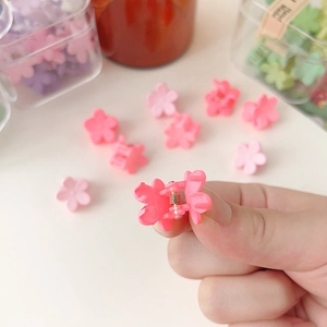Gros plan détaillé de mini pinces à cheveux fleurs mates aux couleurs vives et variées