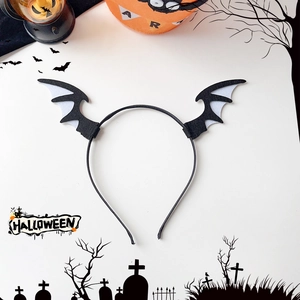 Detail view of black and white bat wing headband on a festive Halloween background