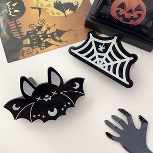 Gros plan sur des pinces à cheveux Halloween avec motifs chauve-souris et toile d'araignée