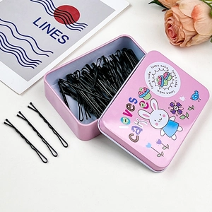Scatola di latta rosa con coniglietto e forcine per capelli nere ondulate su sfondo chic