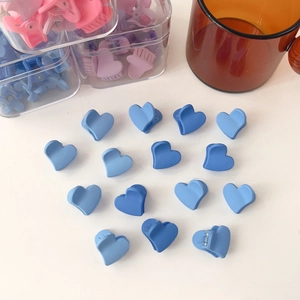 Vue rapprochée de mini-pinces à cheveux en forme de cœur bleu avec fini mat