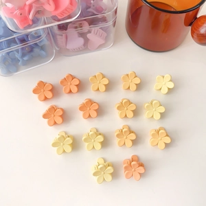 Vue à plat de barrettes à fleurs mates colorées en forme de cœur sur fond blanc