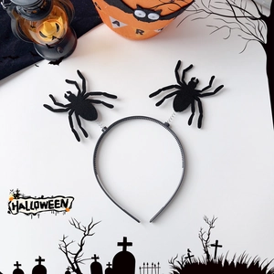 Close-up of Halloween headband with black felt spiders on springs over festive backdrop