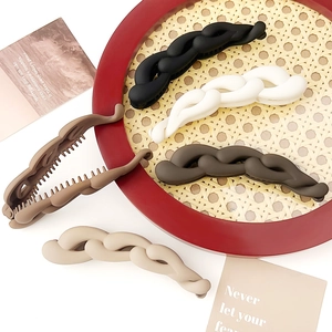 Set di 5 fermagli a banana intrecciati opachi in colori neutri su vassoio intrecciato