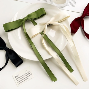 Detail of long satin ribbon bow hair clips in multiple colors with elegant silk texture