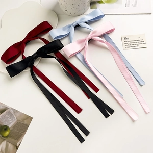 Close-up of elegant satin bow hair clips with long ribbons in assorted solid colors