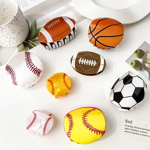 Detalle de varias pinzas de pelo acrílicas con motivos de balones de deporte y fútbol
