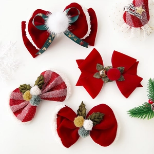 Set of 4 festive Christmas hair clips with red velvet bows and golden bells on white background
