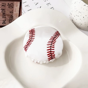 Detalle de pinza para el pelo de béisbol en acrílico con costuras rojas sobre plato blanco