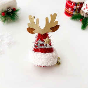 Close-up of a festive Christmas hat hair clip with golden antlers and Merry Christmas text