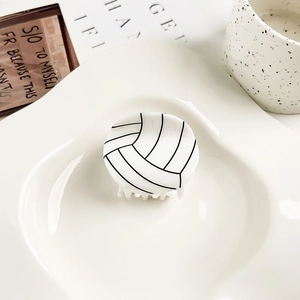 Primer plano de una pinza para el cabello de acrílico blanco con diseño de voleibol