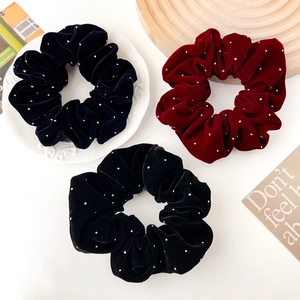 Détail de chouchous en velours avec strass en bleu marine, bordeaux et noir chic