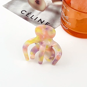 Détail de la pince à cheveux en acétate à motif marbré sur un fond de style de vie