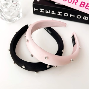 Close-up of handmade rhinestone sponge headbands in pink and black silk satin finish