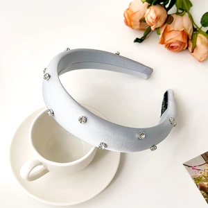 Detail of light blue padded rhinestone headband with satin finish and anti-slip lining