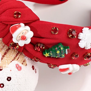 Détail d'un serre-tête de Noël rouge avec Père Noël, sapin et strass brillants festifs