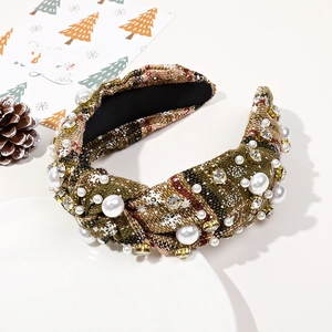 Détail du serre-tête de Noël avec perles et strass sur tissu tricoté épais à carreaux