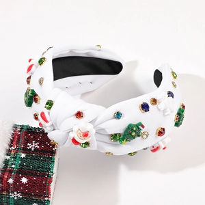 Détail d'un serre-tête de Noël blanc orné de motifs Père Noël, sapins et strass colorés