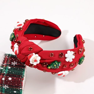 Détail du serre-tête de Noël rouge avec tissu noué, strass et motifs de Père Noël